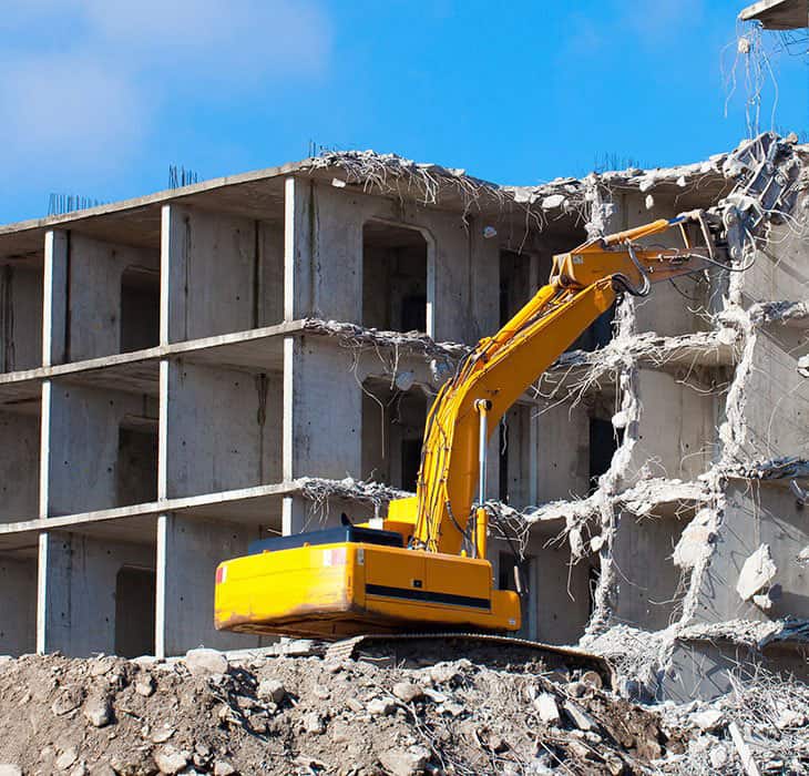 building demolition using excavator in progress